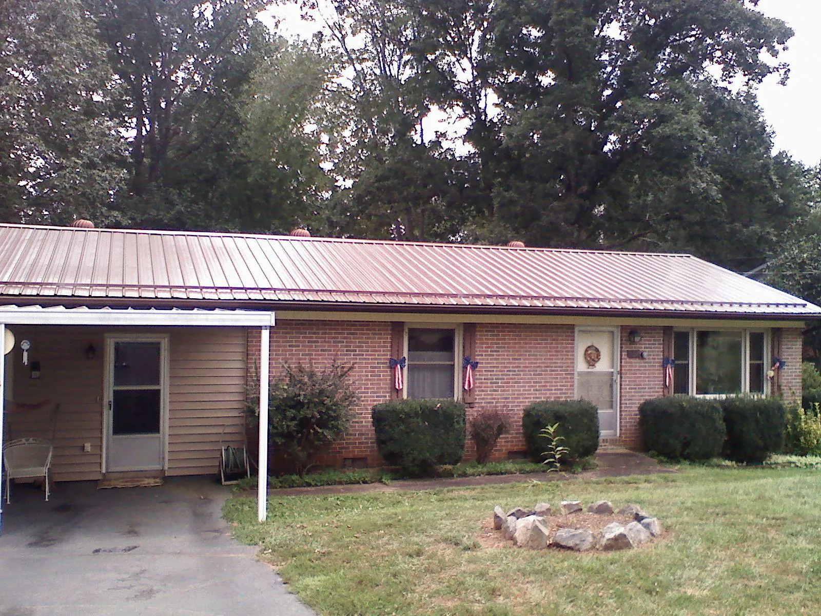 Bronze metal roof and carport on a brick ranch home — Roof Repair work by our crew in Salem